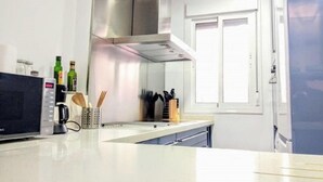 A modern kitchen with a microwave, a coffee maker, and a knife block. - Duplex Sweet Home by SevillaLuxurySuites (Sevilla)