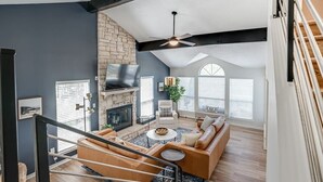 A spacious living room with a fireplace, a staircase, and a large window. - Lakeside Paradise, lake views, hot tub (Canyon Lake)