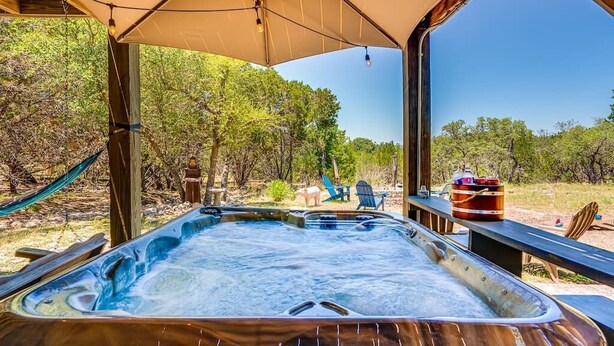 A hot tub under a canopy with a view of trees and a picnic table with a cooler. - Lakeside Paradise, lake views, hot tub (Canyon Lake)
