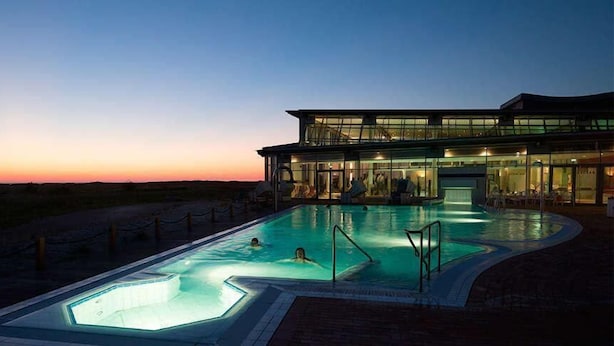 Un hotel moderno con piscina al crepuscolo.