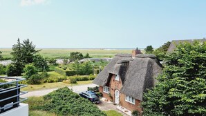 A thatched-roof house with a garden and a view of the sea. - Haus Quisisana Fewo Nr.22 (St. Peter-Ording)