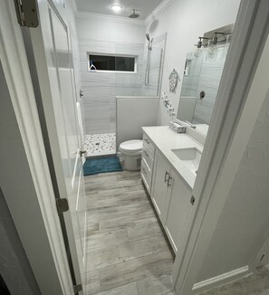 Un baño moderno con ducha, inodoro y lavamanos.