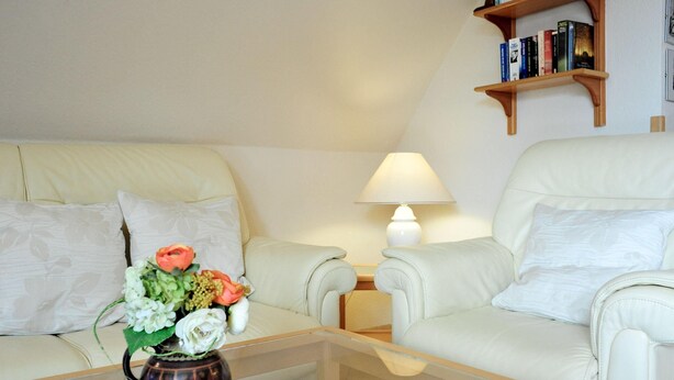 En stue med sofa, sofabord, lampe og reol.