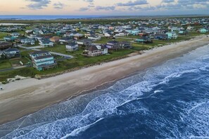 Luftaufnahme einer Küstenwohngegend mit Häusern entlang des Strandes und des Ozeans.