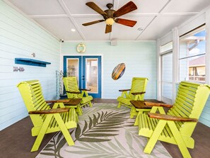 A room with a ceiling fan, a door with glass panels, and a wall-mounted light switch.