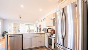 Una cucina moderna con elettrodomestici in acciaio inossidabile, lavastoviglie e forno a microonde.