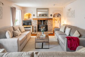 A living room with two sofas, a coffee table, a fireplace, and a television. - Homestead, Southrepps, Norfolk (Southrepps)