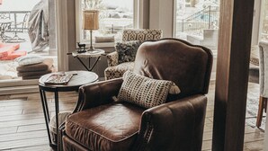 A brown leather armchair with a cushion, a small round table with a lamp, and a sign reading "LAKE HOUSE" on the wall. - HEAVENLY Portage Lakes water front 4-bedroom cottage with HOTTUB, dog friendly! (Akron)