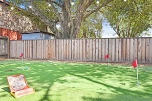 A backyard with a wooden fence, a tree, and a lawn. - Wine Country Backyard Escape (Santa Rosa)