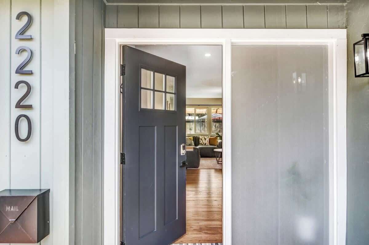 A residential entrance with a dark door, a mailbox, and a number '2220' on the wall.