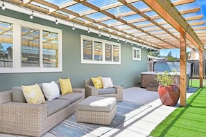 An outdoor patio with wicker furniture, a pergola, and a potted plant. - Wine Country Backyard Escape (Santa Rosa)