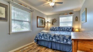A bedroom with a bed, a ceiling fan, and a wooden table. - Beautiful 4 bedroom 2 full bathroom close to everything! (Champaign)
