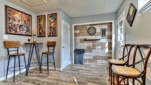 A dining area with wooden flooring, three bar stools, and two chairs. - Beautiful 4 bedroom 2 full bathroom close to everything! (Champaign)
