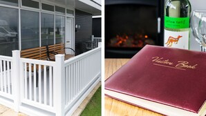 A covered outdoor area with a bench and a table with a bottle and glass. - 57 Cherry Park (Skegness)