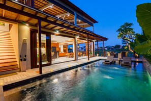 Um resort moderno com piscina, área de estar ao ar livre e um terraço coberto.