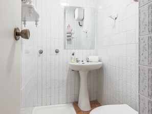 Banheira, secador de cabelo, toalhas de banho