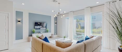 Un salon moderne avec un canapé, une table basse et un téléviseur.