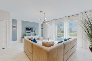 A modern living room with a sofa, a coffee table, and a TV.