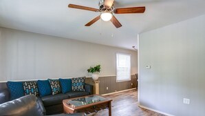 A living room with a sofa, coffee table, and a ceiling fan.