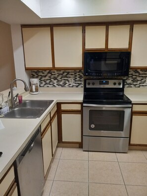Efficient kitchen with a dishwasher, double oven, microwave, sink, and coffee maker.