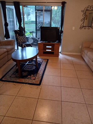 Relax in this inviting living room with a large flat-screen TV, comfortable sofa, and stylish coffee table.