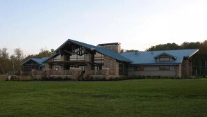 A large, modern house with a stone facade, a prominent gable roof, and a spacious front yard. - 5-BR House/Backyard/2 Lakes/4 Beaches/3Pools/Playgrounds (Pocono Lake)