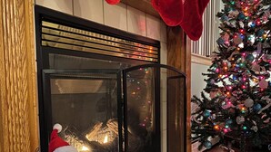 A fireplace with a Santa Claus decoration, a Christmas tree, and red stockings hanging above. - 5-BR House/Backyard/2 Lakes/4 Beaches/3Pools/Playgrounds (Pocono Lake)