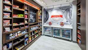 Uma área de exposição de lanches, com prateleiras repletas de diversas marcas e uma seção refrigerada.