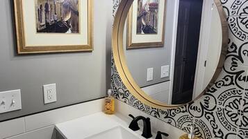 Bañera con ducha, toallas, jabón, papel higiénico