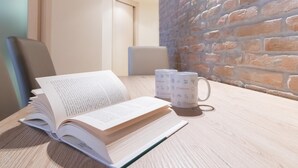 A wooden table with an open book and two coffee mugs. - Italianway Easy - Muratori 8 (Milan)