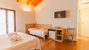 A hotel room with a large bed, a smaller bed, a desk with a chair, a TV, and a door. - in Verona With 4 Bedrooms and 4 Bathrooms (Verona)