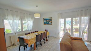 A dining area with a table and chairs, a sofa, and a painting on the wall. - Marlene - private pool villa with sea views from the rooftop in Calpe (Calpe)