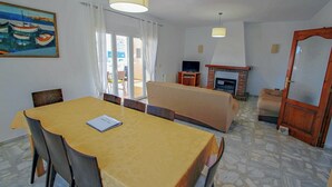 A dining area with a table and chairs, a sofa, a fireplace, and a painting on the wall. - Marlene - private pool villa with sea views from the rooftop in Calpe (Calpe)