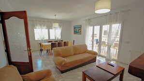 A living room with a sofa, a coffee table, and a dining area with chairs and a table. - Marlene - private pool villa with sea views from the rooftop in Calpe (Calpe)