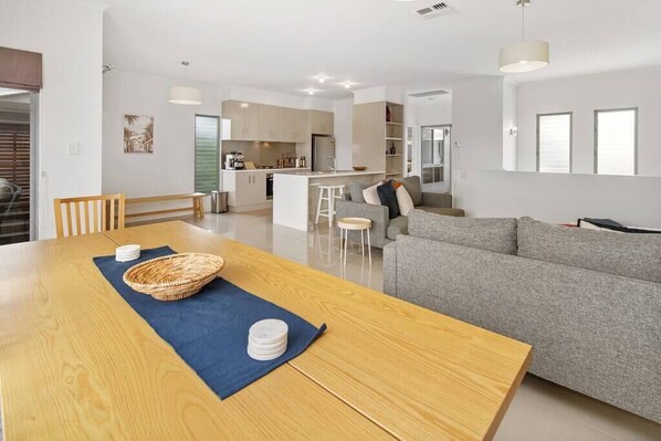 A modern living space with a dining area, kitchen, and seating area.