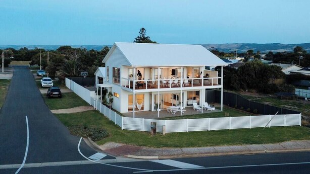 Une maison à deux étages dotée d’un balcon, d’une allée et offrant une vue sur les environs.