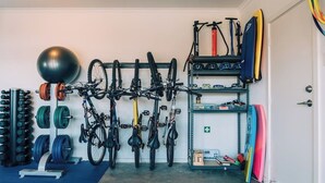 Une salle de sport à domicile équipée de vélos, d’un vélo d’appartement, de disques de poids et d’un kettlebell.