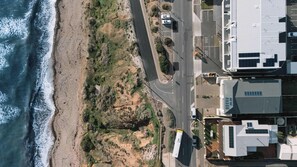 An aerial view of a coastal road with buildings and a beach. - Sunset Ocean Views Esplanade, 6 BR, Sleeps 15 (Sellicks Beach)