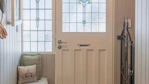Eine Holztür mit Glasfenster und einem dekorativen Wappen.
