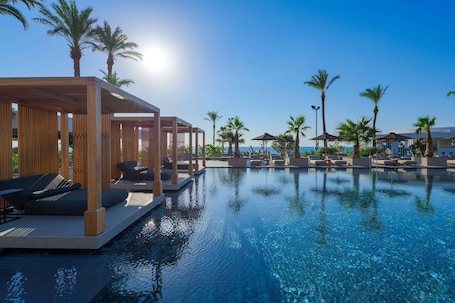 Outdoor pool, pool umbrellas, pool loungers. Ammades All Suites Beach Hotel & Spa - Adults Only