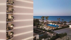 A modern hotel with multiple balconies, a pool area, and a view of the sea. - Ammades All Suites Beach Hotel & Spa - Adults Only (Rhodes)