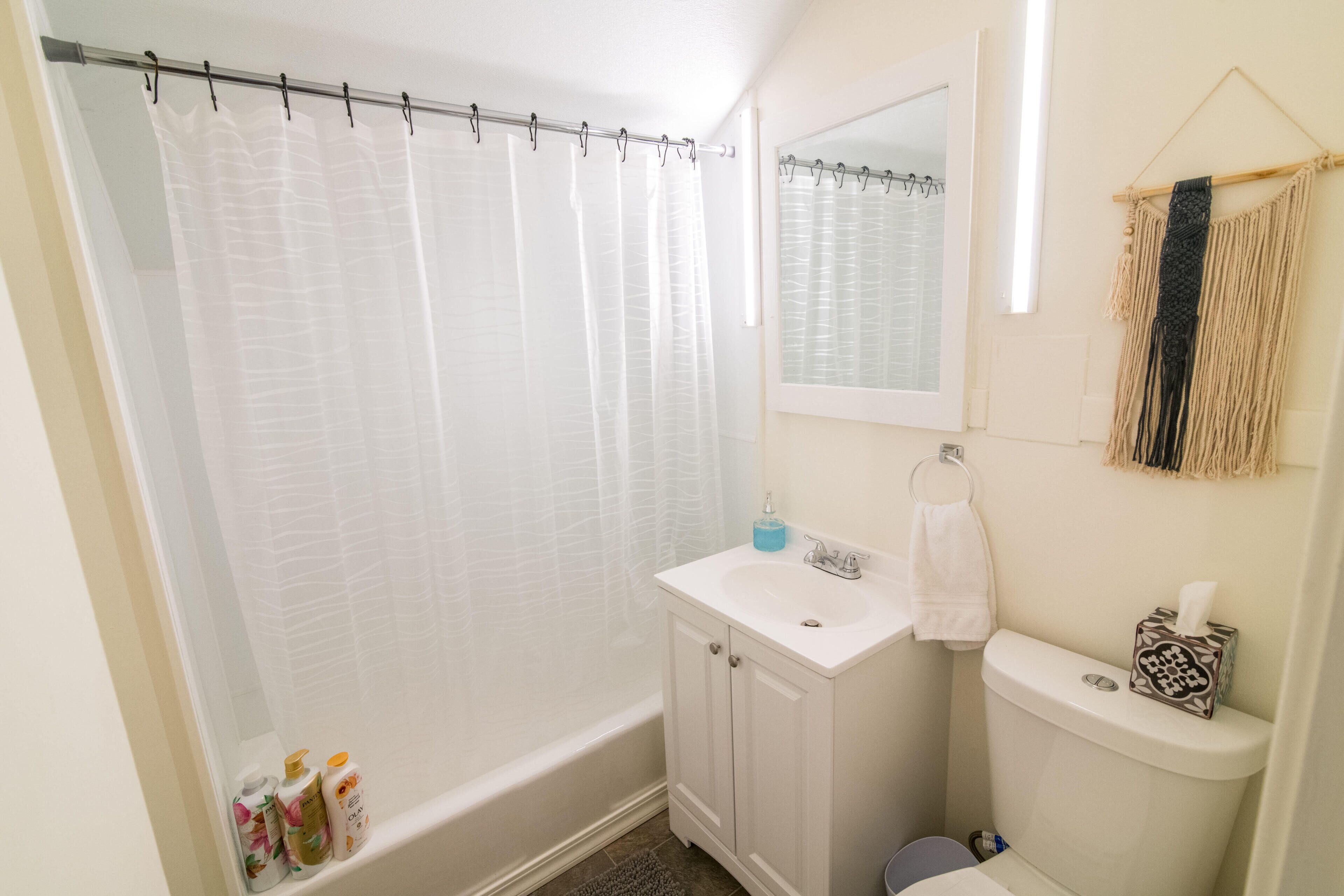 Ein Badezimmer mit Badewanne, Toilette, Waschbecken und Spiegel.