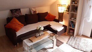 Un salon avec un canapé, une table basse et une bibliothèque.