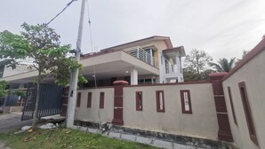 A two-story house with a balcony on the upper floor, a gated entrance, and a well-maintained lawn. - OYO Homes 90524 Dj Pegaso Serom Homestay (Sungai Mati)