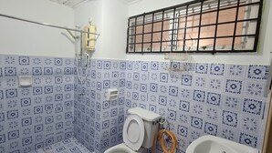 Une salle de bain équipée de toilettes, d’un bidet et d’une douche.