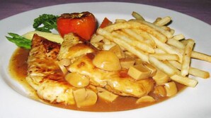 A plate with grilled fish, potatoes, and French fries. - P.S. Hotel -SHA Plus (Patong)