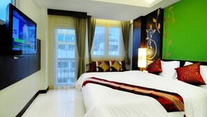 A hotel room with a large bed, a television on the wall, and a window with curtains. - P.S. Hotel -SHA Plus (Patong)