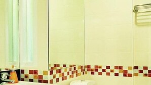 A bathroom with a white sink, toilet, and a shower area. - P.S. Hotel -SHA Plus (Patong)