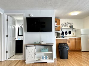 Cozy living space with a flat-screen TV, kitchenette, and separate room.