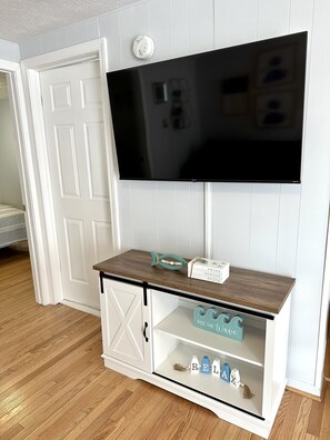 Enjoy a comfortable stay with a flat-screen TV and stylish cabinet featuring decorative elements.